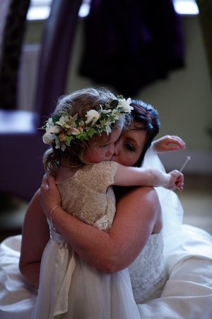 Bride sharing a tender moment with bridesmaid daughter